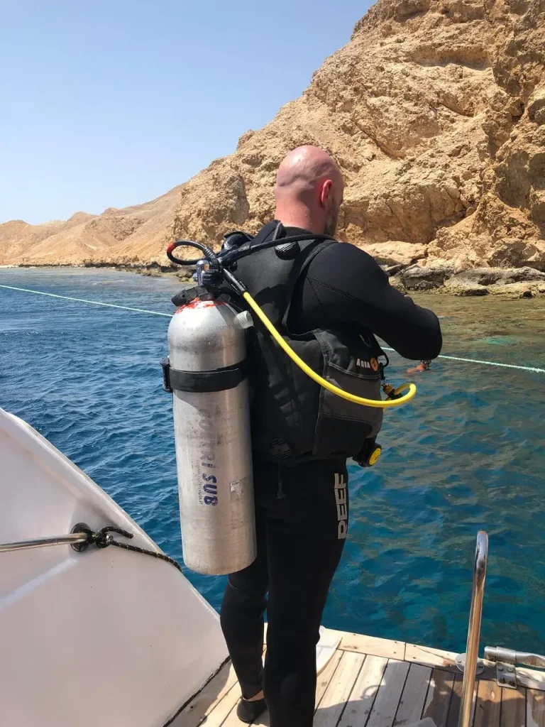Mężczyzna przygotowyjący się do skoku na naszej łodzi podczas kursu Open Water Diver PADI organizowany przez Wycieczki Hurghada